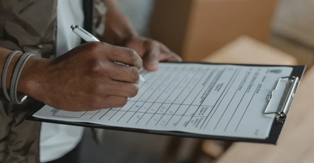 A close-up view of a construction site, with workers and machinery in the background. In the foreground, a detailed chart displaying the estimated cost per square meter of construction, presented on a sturdy clipboard. The chart is well-organized, with clear and concise data visualization. The lighting is natural, with soft shadows and highlights that accentuate the textures of the materials. The overall tone is professional and informative, conveying the seriousness and importance of the subject matter. plantas de casa térrea 2 quartos 1 suite
